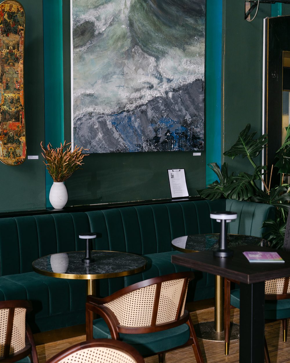 Innenraum der Sasa Brunch Bar mit dunkelgrünen Wänden und Samtbänken