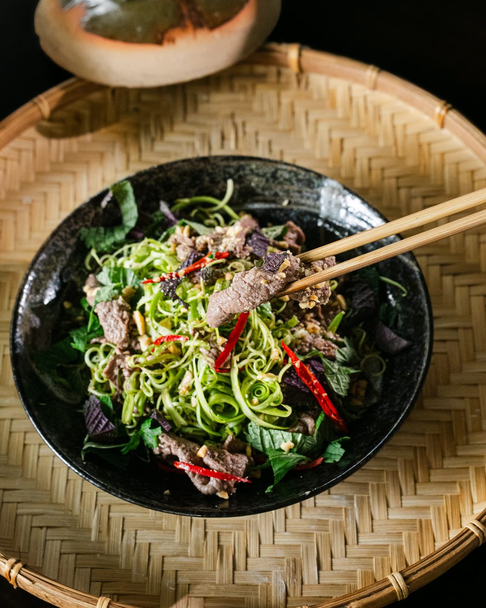 Rindfleischsalat mit Kräutern und Chili auf Bambuskorb